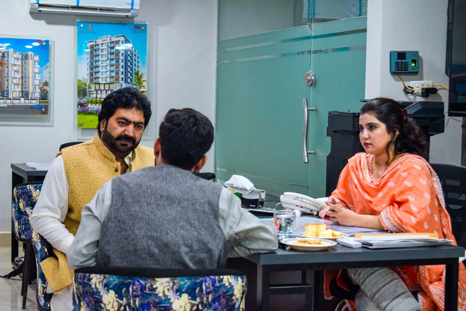অফিসের টেবিলে তিনজনের পেশাগত আলোচনা